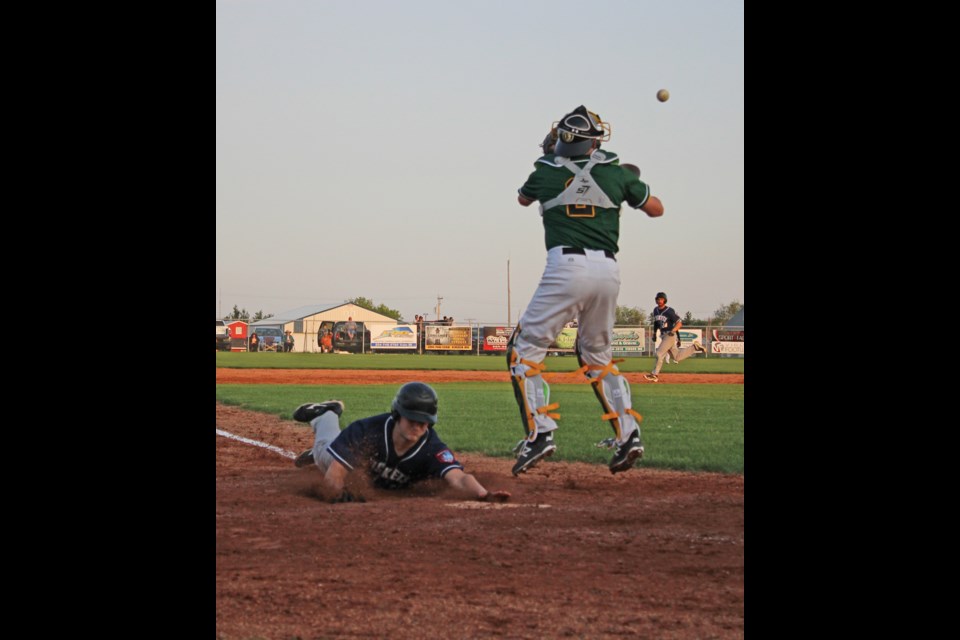 Reston player slides into home, helping lift the Rockets over the Virden Oilers 9-6 on June 6 in Virden. In the background, a runner takes third base.