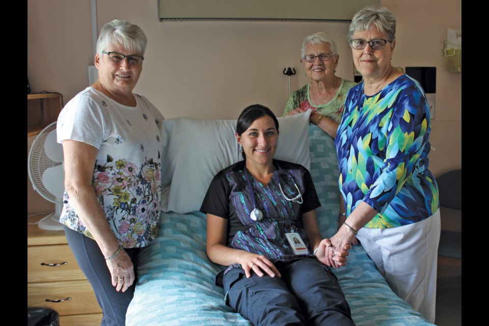 Client Care Coordinator Jolene Lowes (centre) tries out the new palliative care bed at Virden Hospital surrounded by volunteers who donated $15,000 to buy it. (l-r) Fran Preston, Lil Wadham, and Barbara Heaman represent Virden’s palliative care group.