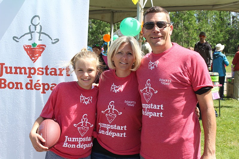 Canadian Tire owners Mike and Jackie Howell pose for a picture with their daughter Brie during the J