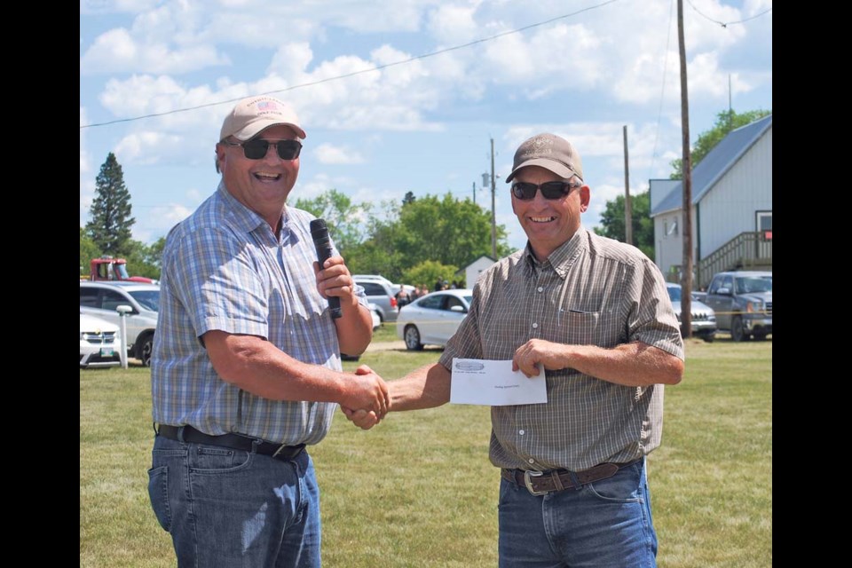 Reeve of RM of Wallace-Woodworth Denis Carter (l) is presenting a donation to the Harding Agricultural Society at the Harding State Fair opening ceremonies.