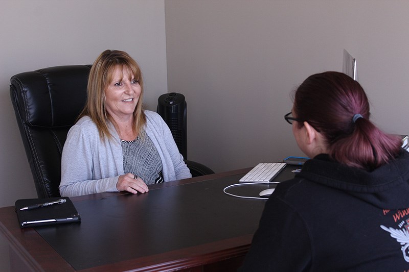 Michele Nichol-Sawh talks with a co-worker at the new MAPS office at 117 Commercial Place.