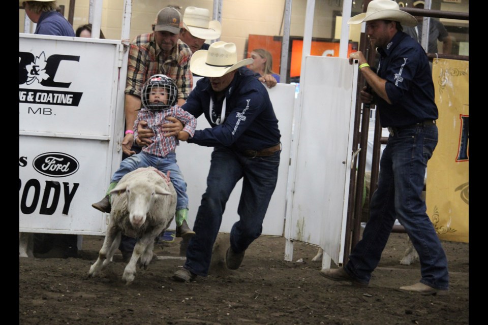Getting a taste of rodeo at a young age, as dad swoops the little one off in Virden Indoor Rodeo's intermission entertainment.