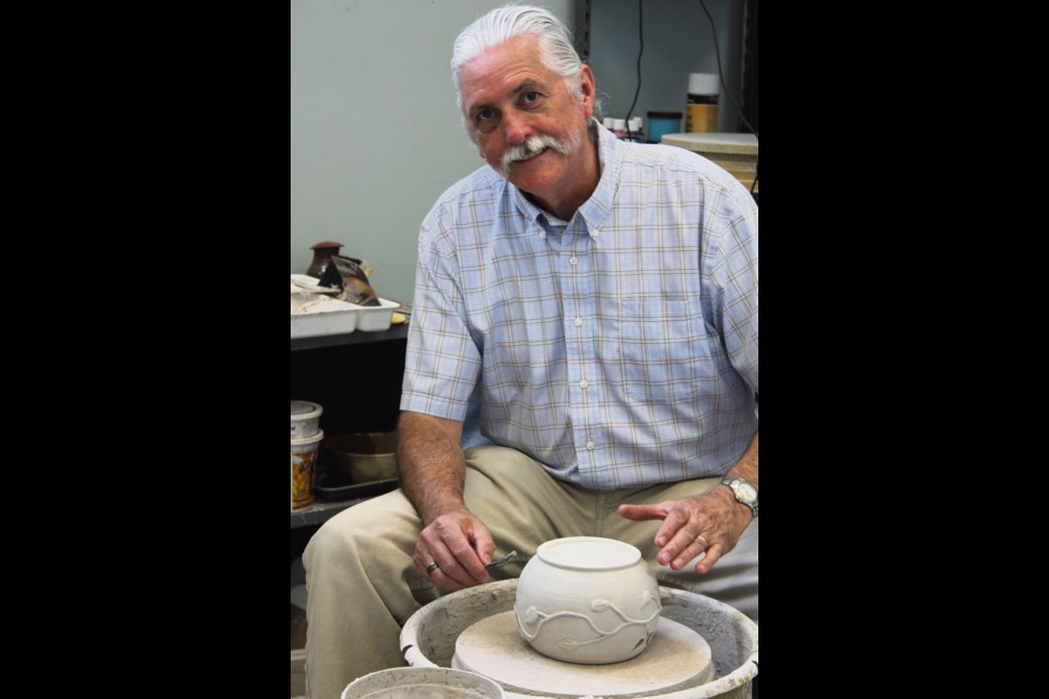 Ken Marshall at the potter’s wheel in his studio in the rear of his chiropractic office.