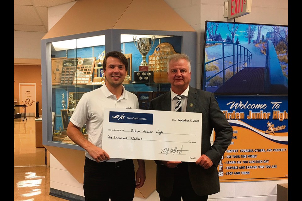 Reid Gow presents a $1,000 donation to Don Nahachewsky, Principal of VJH for the breakfast program.