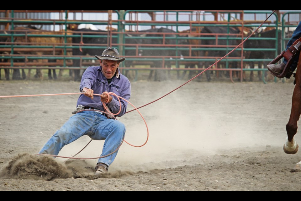 A ring steward takes a brake to have fun, skiing behind the dummy-roping calf.