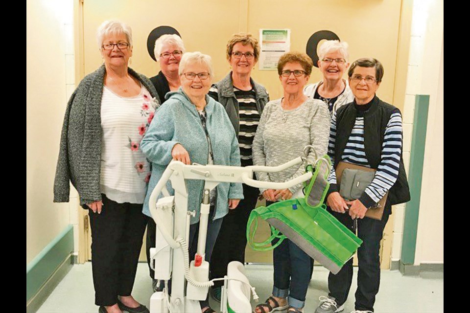 Members of the Virden and District Health Auxiliary posing with a new piece of health equipment, a sit stand, purchased by the auxiliary for the West-Man Nursing Home.