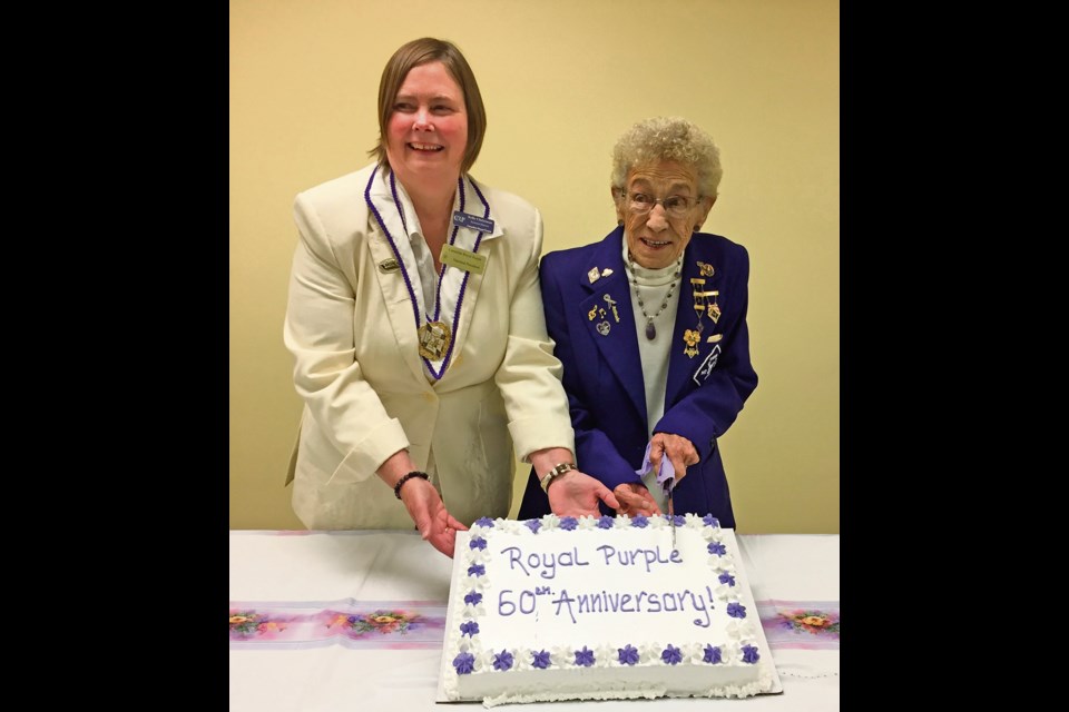 National President of Canadian Royal Purple Kelly Christman of Bassano, Alta. (l), with longstanding Virden member of nearly 55 years, Ruth Dunning. They are preparing to cut the cake at a supper gathering in Virden Baptist Church.