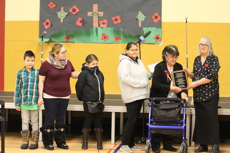 Wapanohk Community School principal Kathleen Kelson (far right) presents Percy Laubmann’s family members with a plaque that summarizes his military service as a member of the Royal Canadian Infantry during Wapanohk Community School’s Aboriginal Veterans Day ceremony Nov. 8.