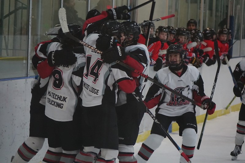 The bantam AAA Norman Wolves celebrate Allan Matechuk’s overtime game-winner against the Central Pla