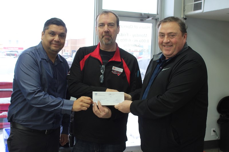 Canadian Tire store manager Rick Mackenzie (centre) accepts a $3,100 cheque from Thompson Ford employees Buddy Little (left) and Art Lafreniere (right) on Nov. 30. This money will go towards funding the local Jumpstart program.