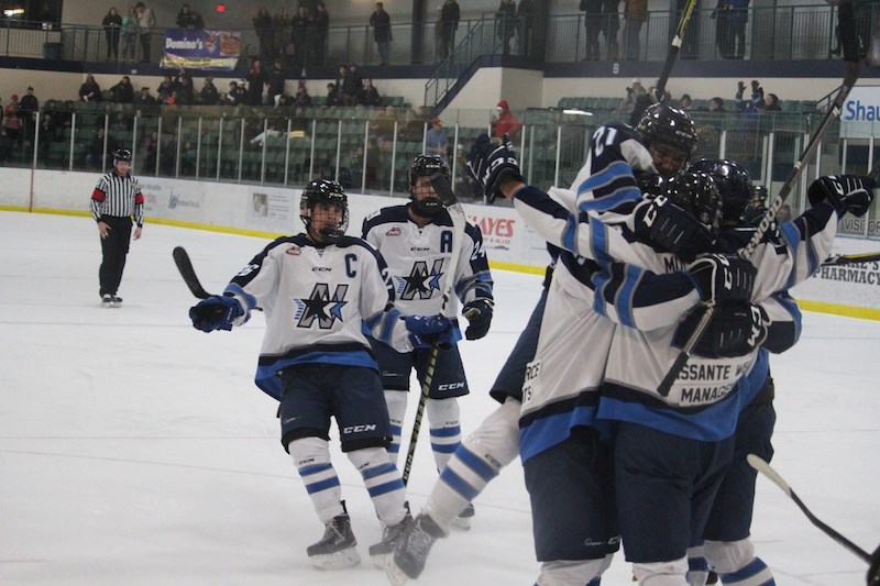 Members of the Norman Northstars mob Henry Muchikekwanape after he scored the game-winning goal in overtime on Saturday, Dec. 8 at the C.A. Nesbitt Arena.