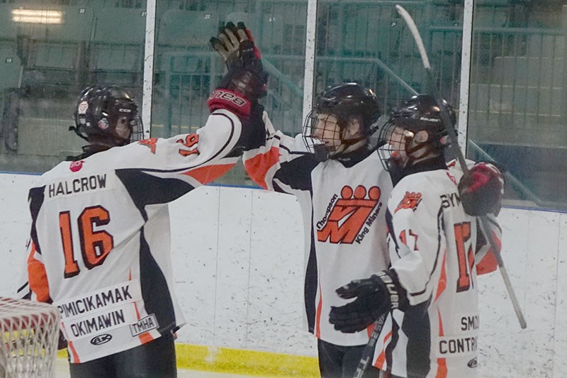 Casper Stoker, centre, celebrates his first of two goals during a 5-3 midget AA Thompson King Miners