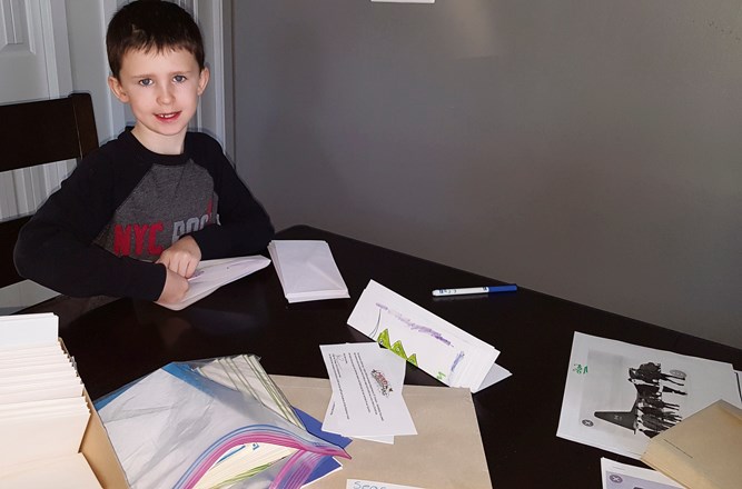 Logan Frizzley (9), son of Shona and Joe Frizzley helps make cards and letters for soldiers of the Canadian Armed Forces.