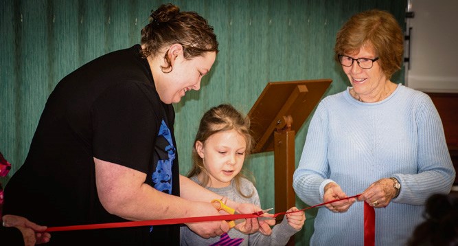 Priscilla Gompf and daughter Serena cut the ribbon with Karen McKinnon, Habitat for Humanity Virden Chair, Jan. 29.