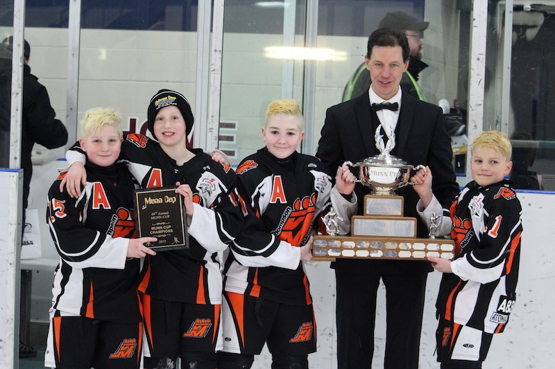 Members of the AA Thompson King Miners brandish the Munn Cup after beating the Swan Valley Stampeders 2–1 in their tournament final on Feb. 17.