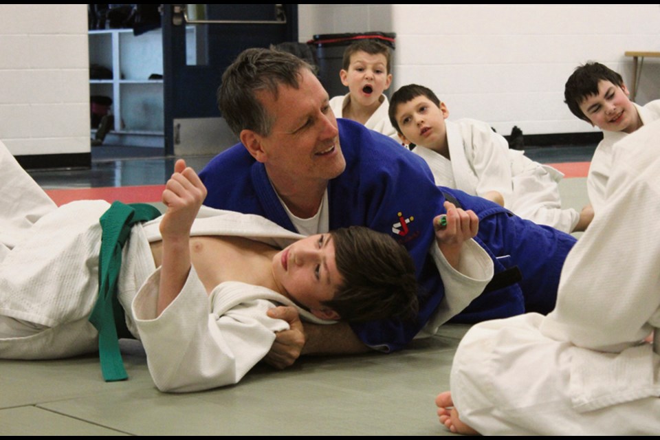 Sensei James Currie, a black belt from Winnipeg, was a special guest of the judo club at Mary Montgomery School Saturday. Here he demonstrates how to pin an opponent. Clockwise from bottom: James Kreutzer, Currie, Ben Morris, Jordan Popaden, and Tanner Dron.