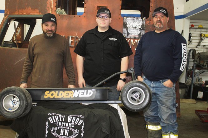 Dirty Word Customz team of rat rod builders: (l-r) Dave Walko, RJ Wiltshire and Dwayne Wiltshire, the 1947 Farmers & Stockmens Bank truck awaiting transformation behind them, a custom made shop wagon displaying Wiltshire’s event sponsor logo - SolderWeld.