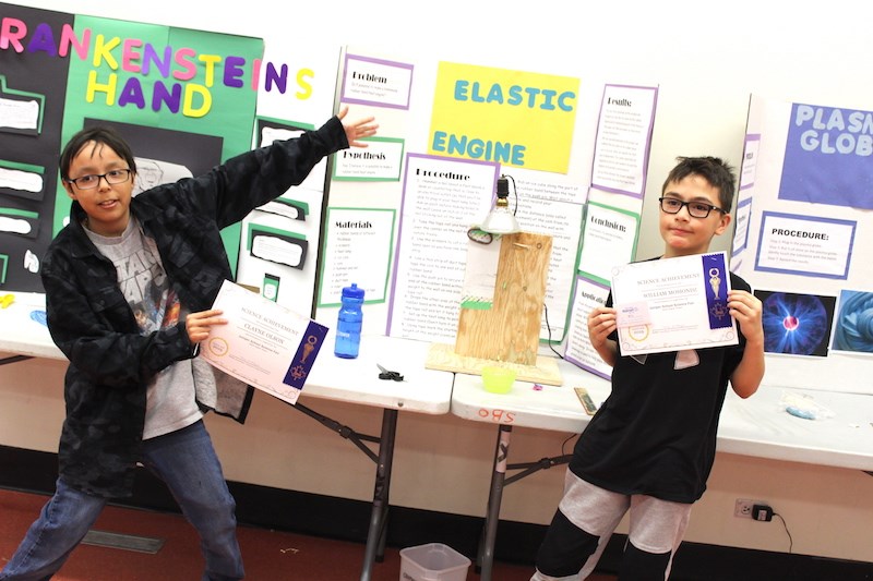 Grade 5 students Clayne Olson (left) and William Mosiondz (right) celebrate winning second place in their category for building a rubber band heat engine.