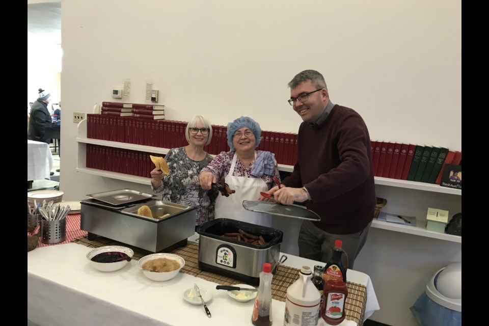 From left to right, Wenndy Ritchat, Leona Mayer and Greg Stott dishing up pancakes and sausages.