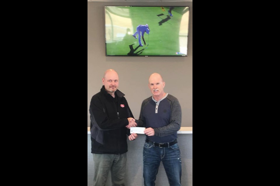 Scott Biccum presents a donation to Virden Wellview Golf Club President Graham Freeman. A big screen LED TV was purchased for the clubhouse and will be dedicated to the Biccum Family and in memory of Les and Joyce Biccum.