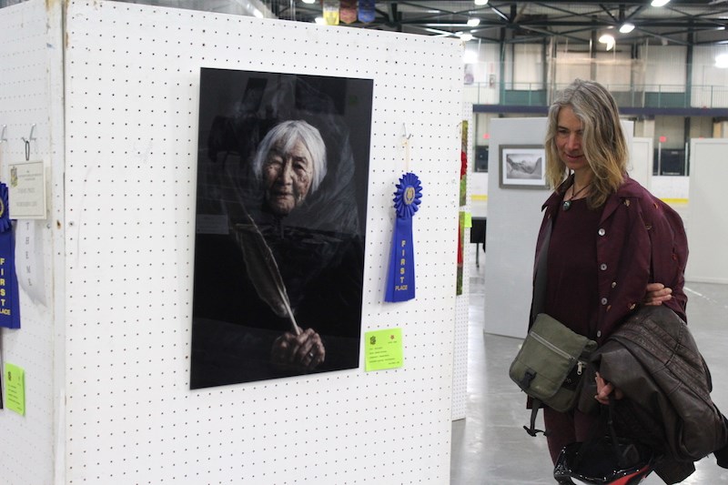 A local art lover checks out some of the top-ranked photography from the 43rd Northern Juried Art Show on Saturday, including a work titled “Our Legacy” by Denare Beach resident Brandy Bloxom.
