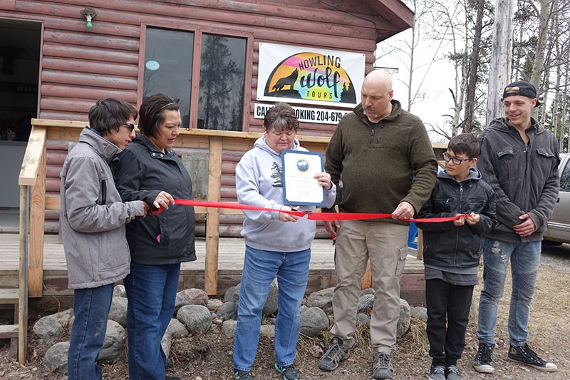 Mayor Colleen Smook cuts the ribbon at the grand opening of Howling Wolf Tours May 17 while company