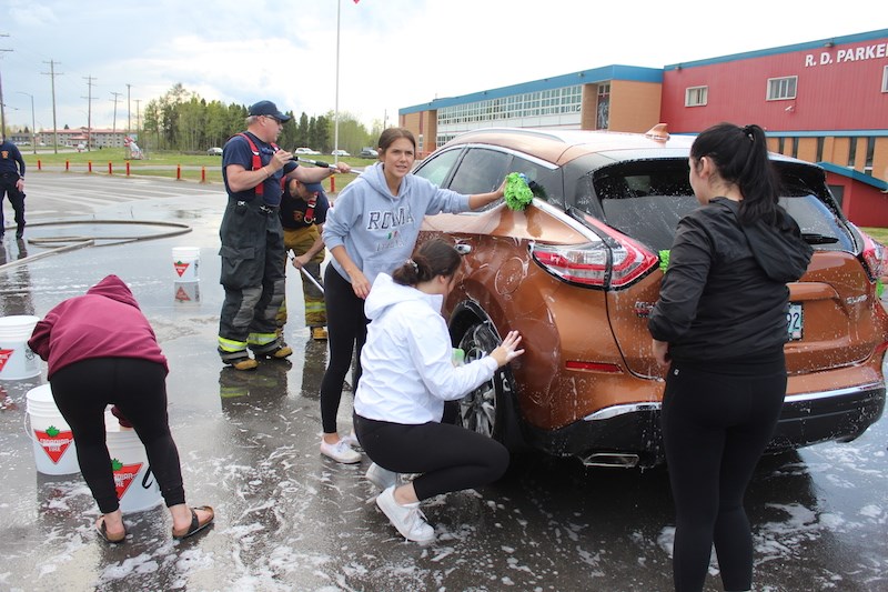 Even though a rainstorm threatened their June 5 car wash, graduating R.D. Parker Collegiate students and Thompson firefighters still managed to raise $770 for the upcoming safe grad party.