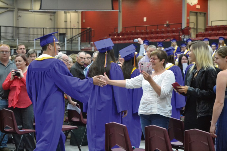 Cole Sparks and his mother Linda Sparks share a high five as VCI students enter the TOGP arena on Tuesday, June 25, 2019.