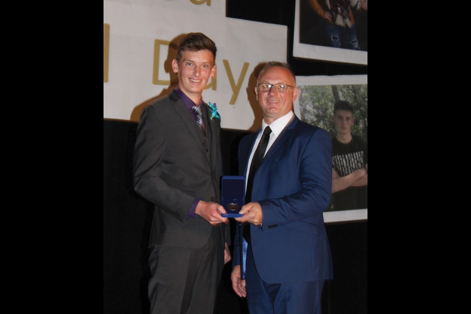 Matthew Bajus (l) accepting the Governor General Academic Bronze Medal from Barry Pitz, Superintendent of Schools. Bajus graduated with 41 credits and an average of 89.5 per cent in his grade eleven and twelve courses.