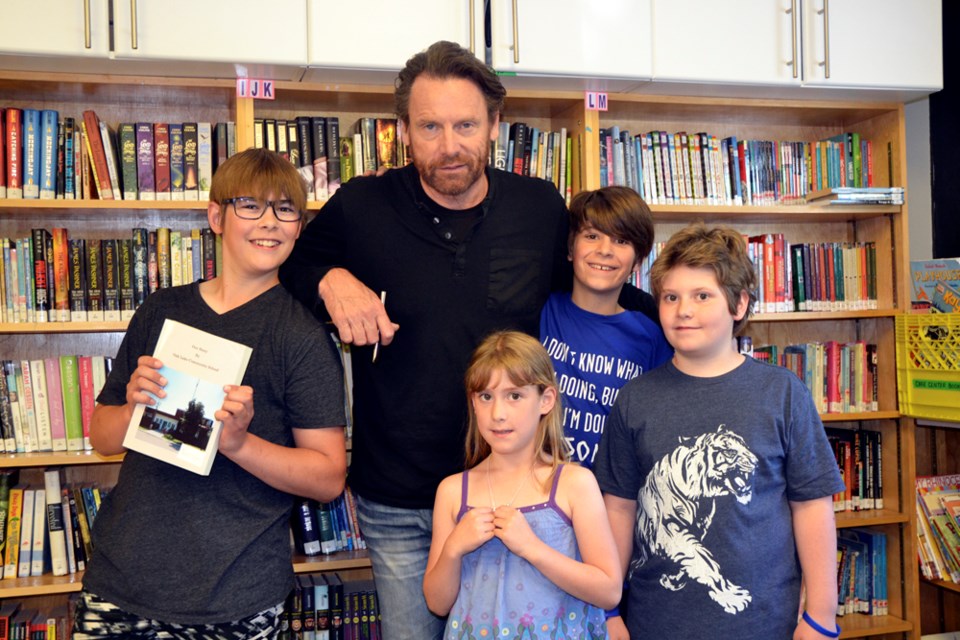 Author Sigmund Brouwer (centre) helped the students of Oak Lake Community School write, draw, and publish their own book. (l-r) Cody (13), Lauren (6), Jamie (11) and Micah Thiessen (9).