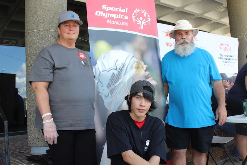 Special Olympics coaches Sherrie Benner (left) and Scott Luxton (right) flank athlete William Hart during a July 27 barbecue fundraiser at MacLean Park. Arctic Beverages, Smook Contractors, Arnason Distributors, Giant Tiger, Brandon McDonald and Brendan Rhodes sponsored this event.