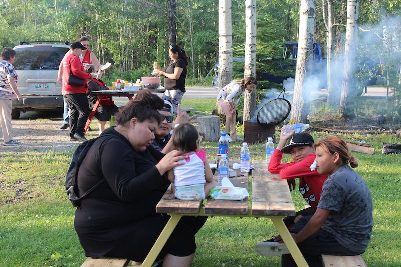 Families from Black Sturgeon Falls, who had to flee their homes July 24 due to nearby wildfires, enjoy a community barbecue at McCreedy Campground in Thompson July 29.