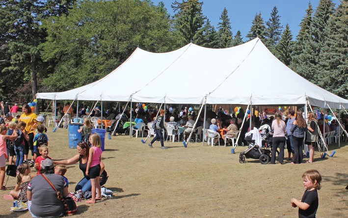 The big white tent, the families, and visiting crowds are the scene in Victoria Park for the Corex noon barbecue Aug. 15.