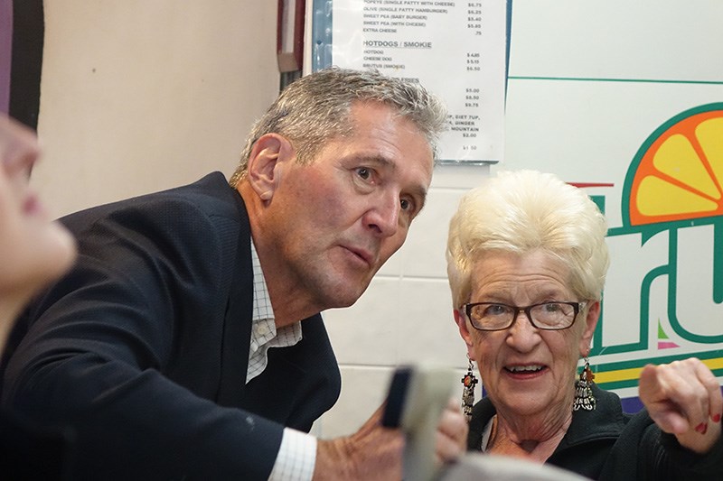 Progressive Conservative leader Brian Pallister talks with Popeye’s owner Alice Lavoie at her restau