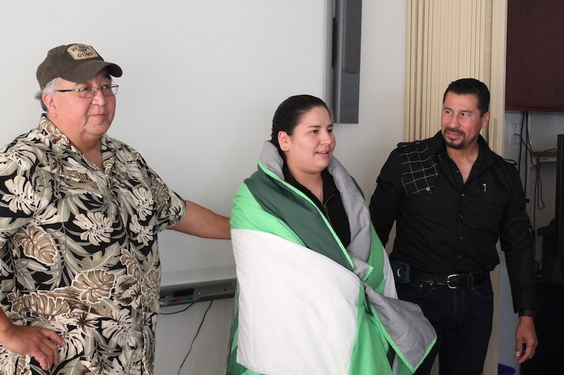 Keewatin Tribal Council CEO George Neepin (left) and health director John Spence (right) congratulate Echo Dumas for saving a woman’s life in God’s Lake First Nation by presenting her with a star blanket during a Sept. 13 ceremony in Thompson