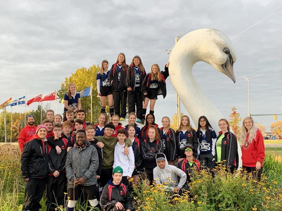 R.D. Parker Collegiate’s boys' and girls’ soccer team pose with the swan statue in Swan River, where