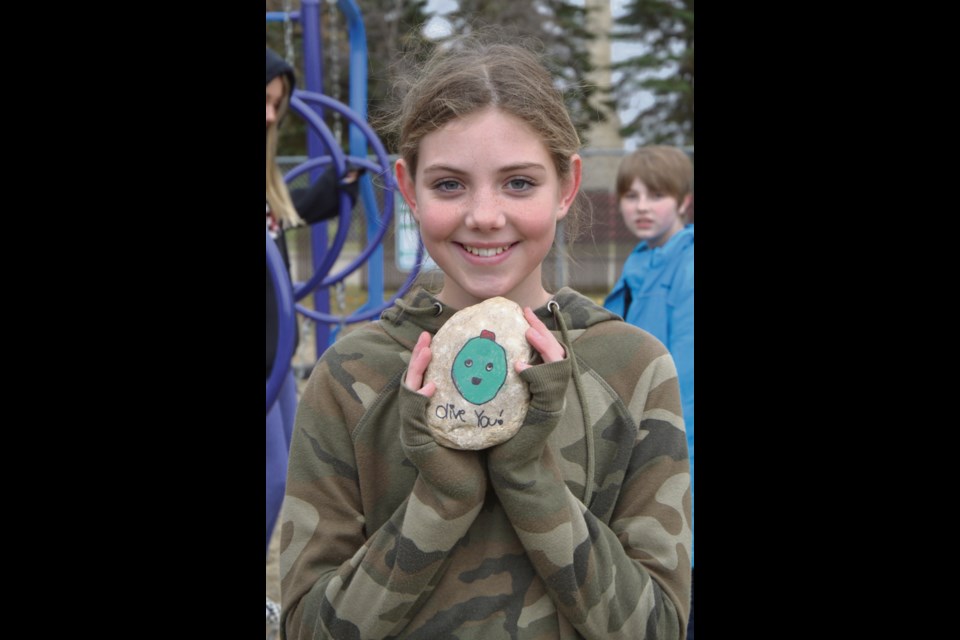 Emily Flannery, Grade 7, with her painted rock: "Olive you"