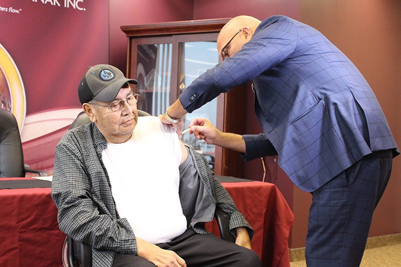 Elder Joshua Morris of Tataskweyak Cree Nation receives his flu shot from Dr. Barry Lavallee of Mani