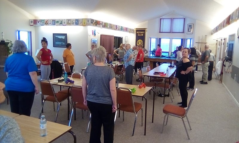 Participants in the Seniors Fun Fitness Program perform exercises at Thompson Rotary Place, led by n