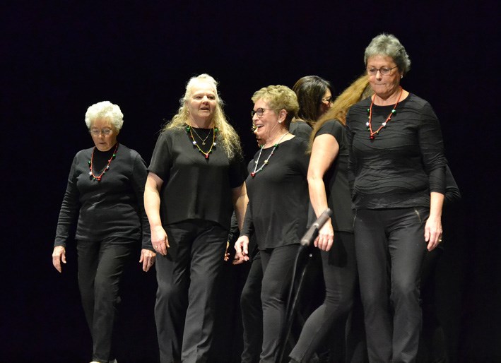 Virden Country Cloggers do a step routine with a distinctive tap clap on the hard Aud Theatre floor, responding to the caller's directions.