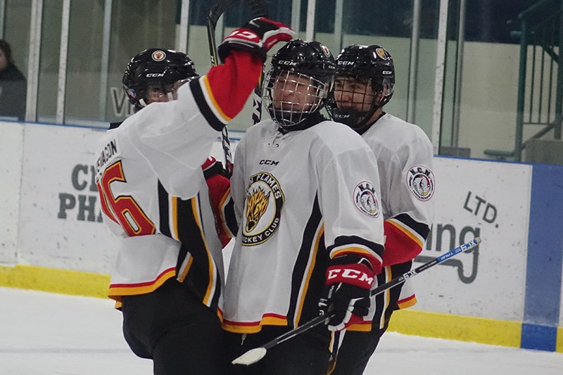 Chase Muswagon congratulates Nisichawayasihk Cree Nation Flames teammate Jerome Linklater after a th