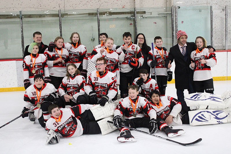The peewee B Thompson Warriors pose for a victory photo after their gold medal win at the Prince-Ber