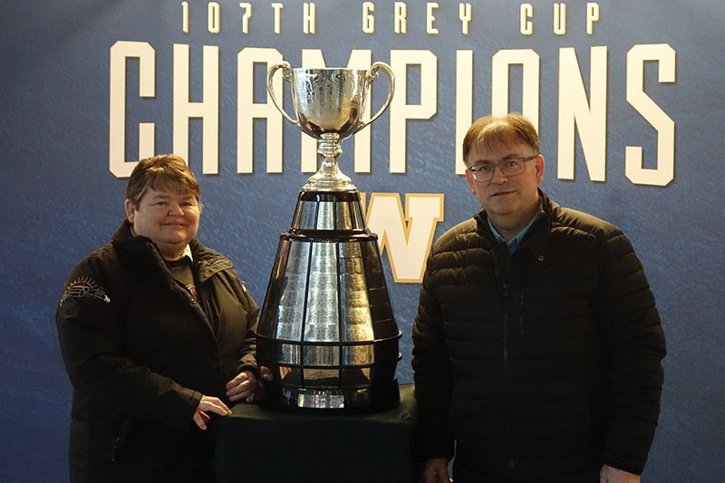 Mayor Collen Smook, left, and deputy mayor Les Ellsworth, right, pose with the Grey Cup, which was on display at the Thompson Regional Community Centre for five hours Feb. 5 as part of the Winnipeg Blue Bombers’ championship tour around the province.