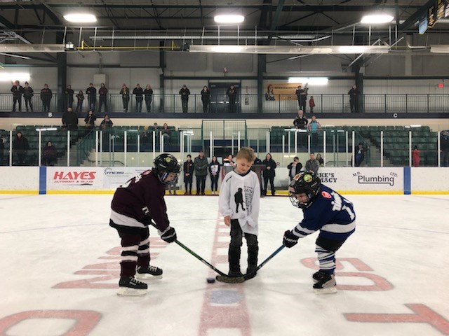 Hunter Zahayko drops the puck for a ceremonial face-off between the Thompson Leafs Hudson Matechuk,