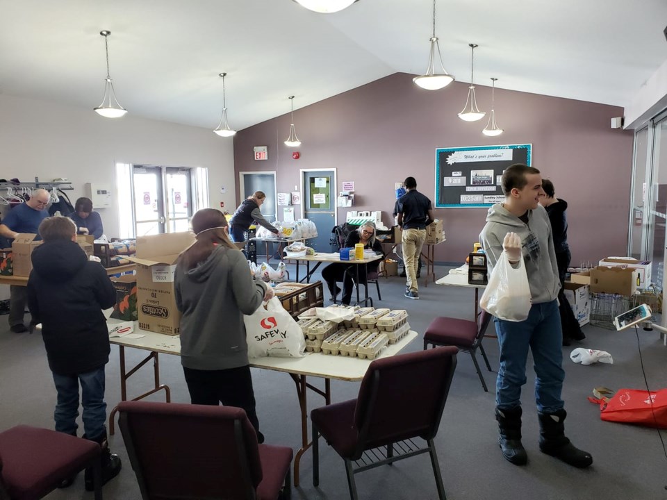Volunteers pack bags with breakfast items at Thompson Pentecostal Assembly April 14.