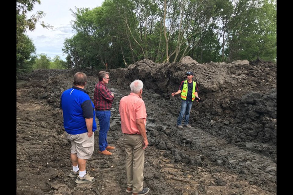 Manitoba Liberal Leader Dougald Lamont surveys a dyke being built to protect a residential area in the Town of Neepawa from further flooding with Mayor Blake McCutcheon, Councillor Jason Nadeau, and Operations Manager Denis Saquet.