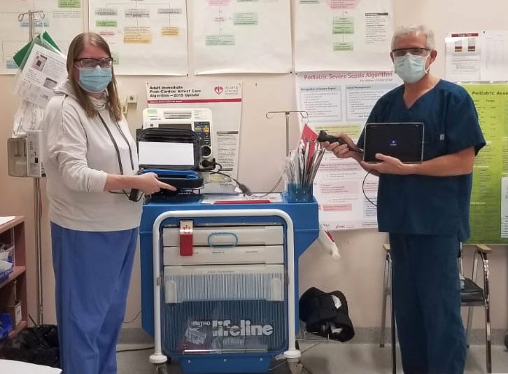 Dr Hammell and Dr Roux with the new Butterfly IQ ultrasound diagnostic device that can be used at bedside, in the emergency room or in the medical clinic.