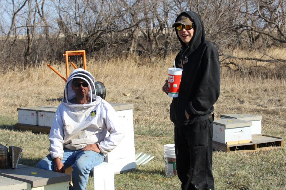 Near the Assiniboine Valley, Michael Cox a local beekeeper and his helper on April 21.