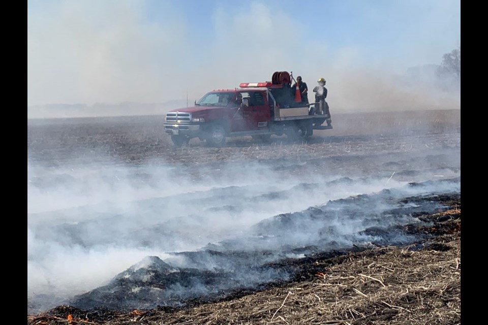 Woodworth Fire Dept. in the stubble field adjacent to the farmsite, surrounded by smoke from grass fire.
