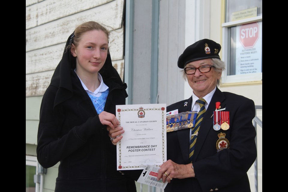 Plainview Colony student Cristina Walder receives an award for her black and white poster from Royal Canadian Legion District 2 Commander Joan Wright on June 21.